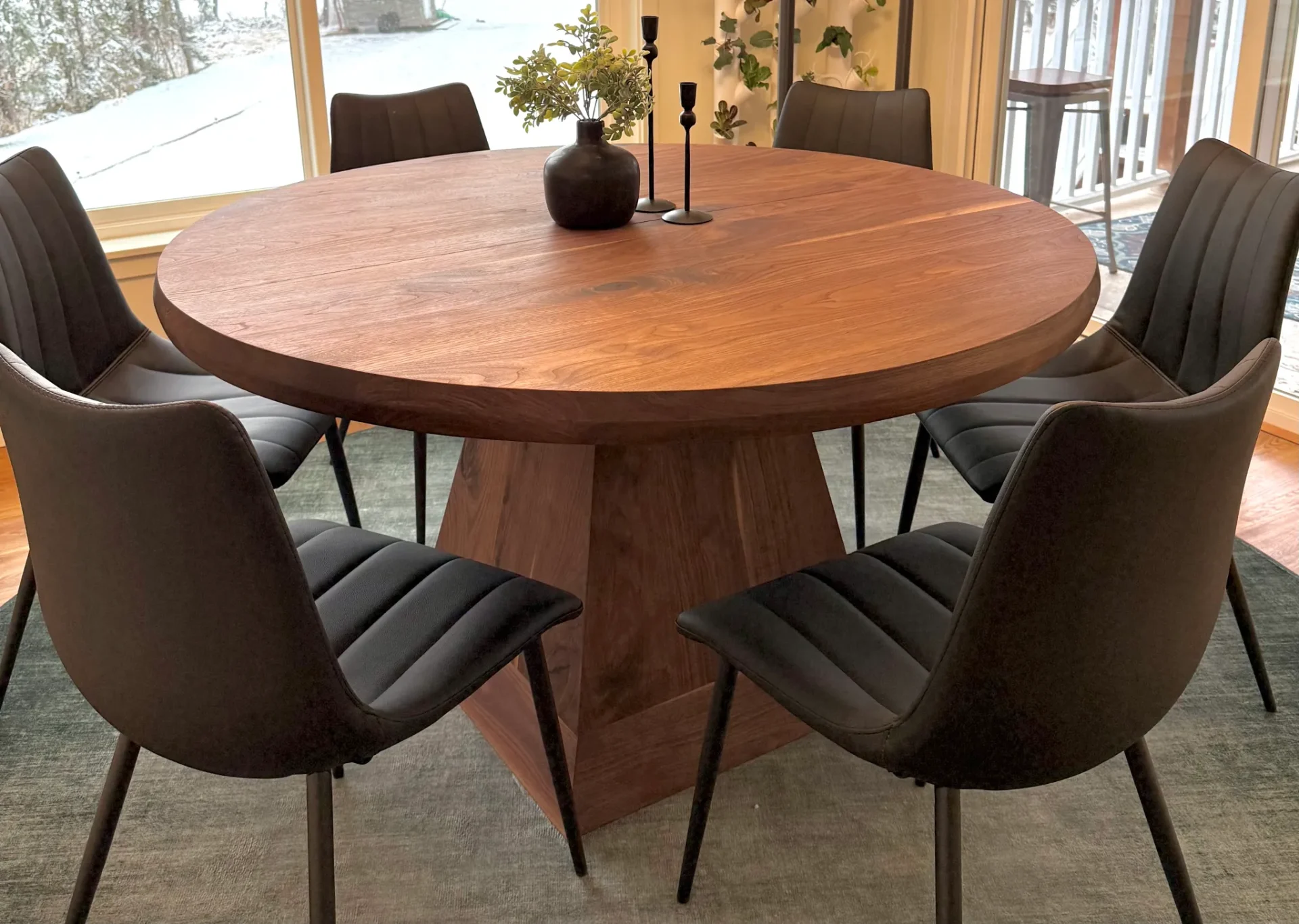 Round walnut expanding dining table with geometric pedestal base